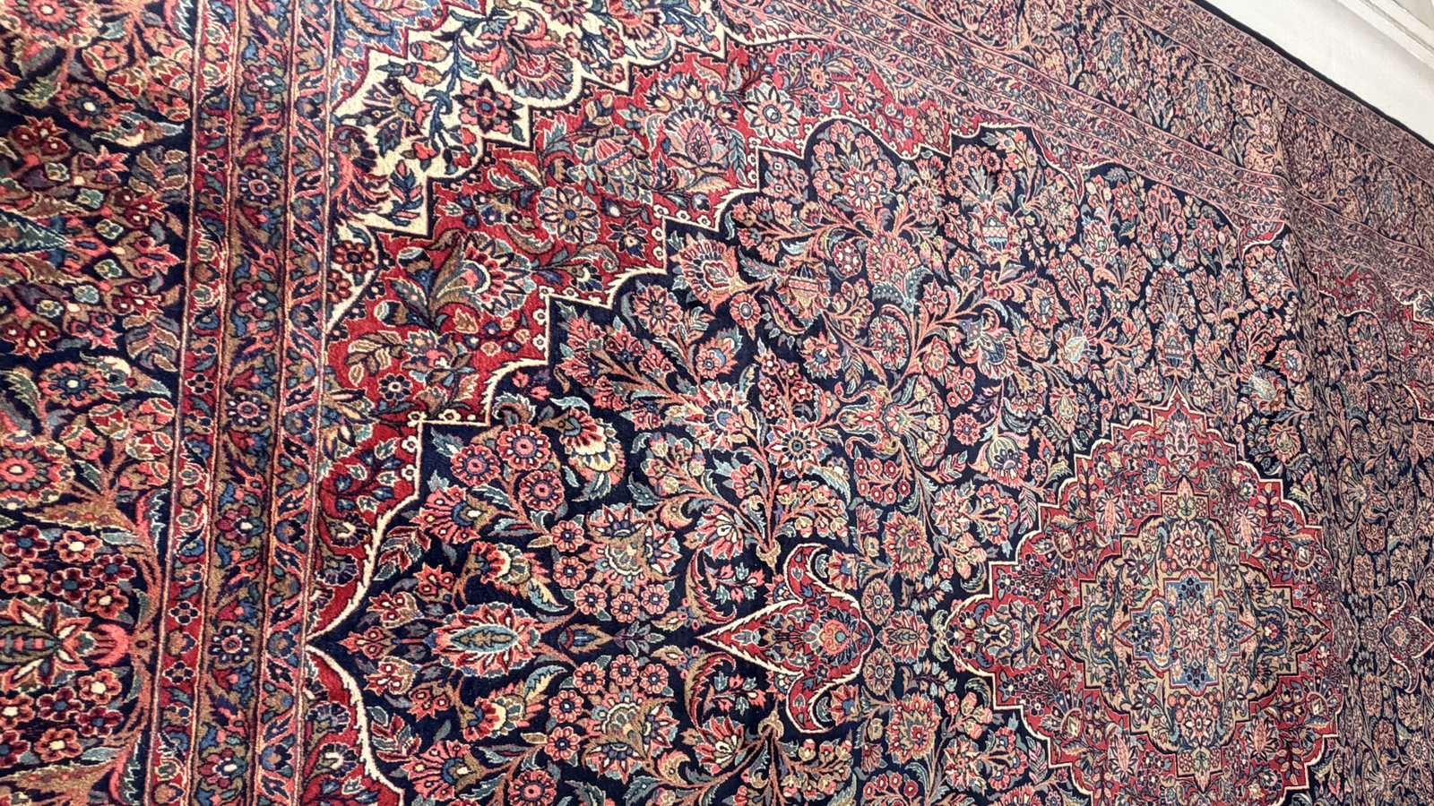 Antique Persian rug hanging for inspection