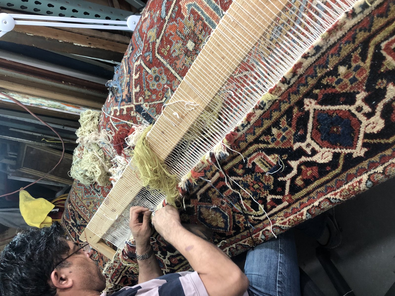 Re-weaving warp threads across a loom frame on an antique rug
